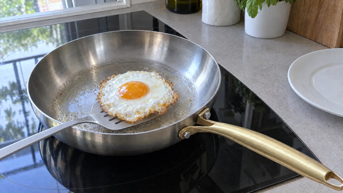 Poêle inox qui ne colle pas : un œuf au plat se décolle entier sous la spatule, sur une plaque à induction