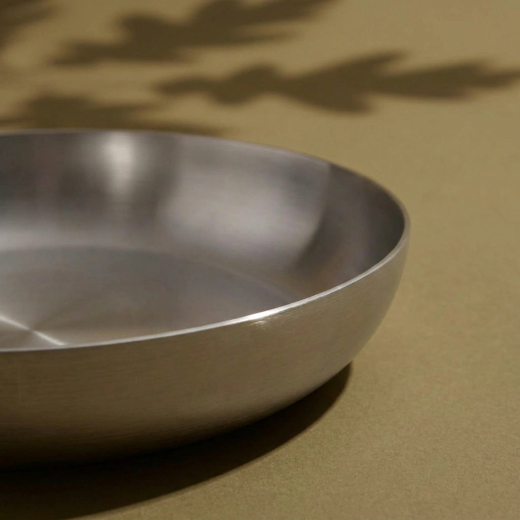 Bord arrondi et surface de cuisson brossée de la poêle tous feux 22 cm, vus en gros plan