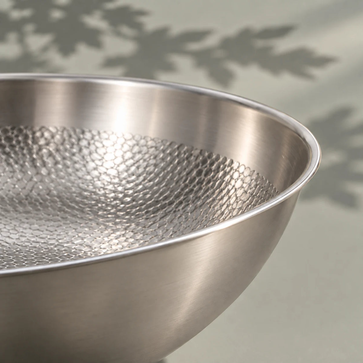 Bord du wok en titane 32 cm vu de près, sa paroi haute et lisse au-dessus de la surface de cuisson martelée