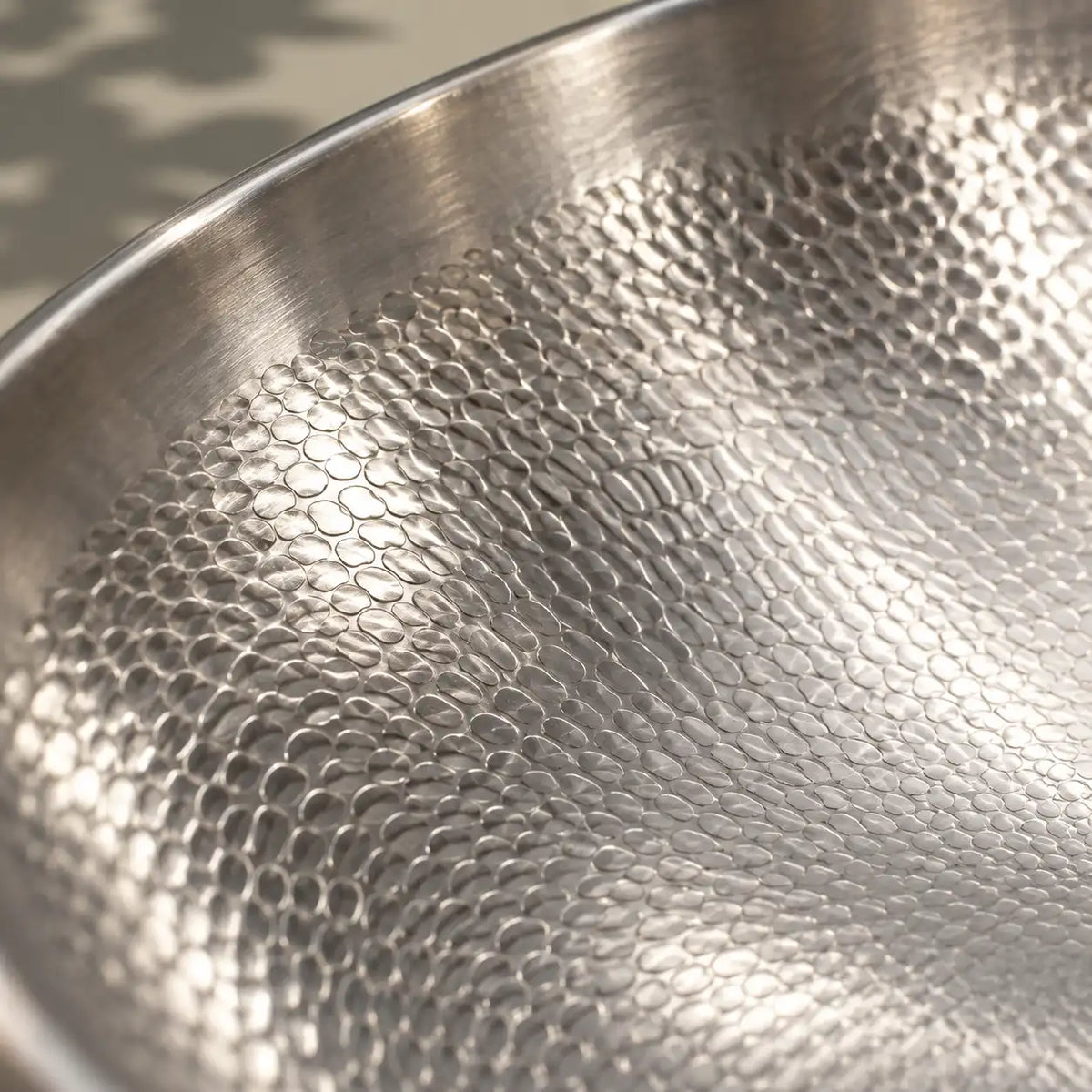 Gros plan sur les alvéoles en titane pur de la surface de cuisson du wok en titane martelé 32 cm