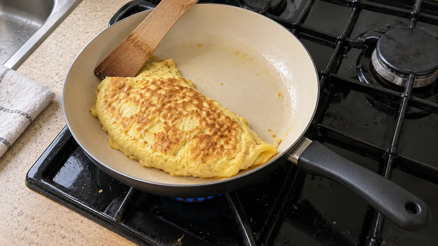 Durée de vie d'une poêle en céramique : une omelette dorée qui glisse dans une poêle encore antiadhésive, sur la gazinière