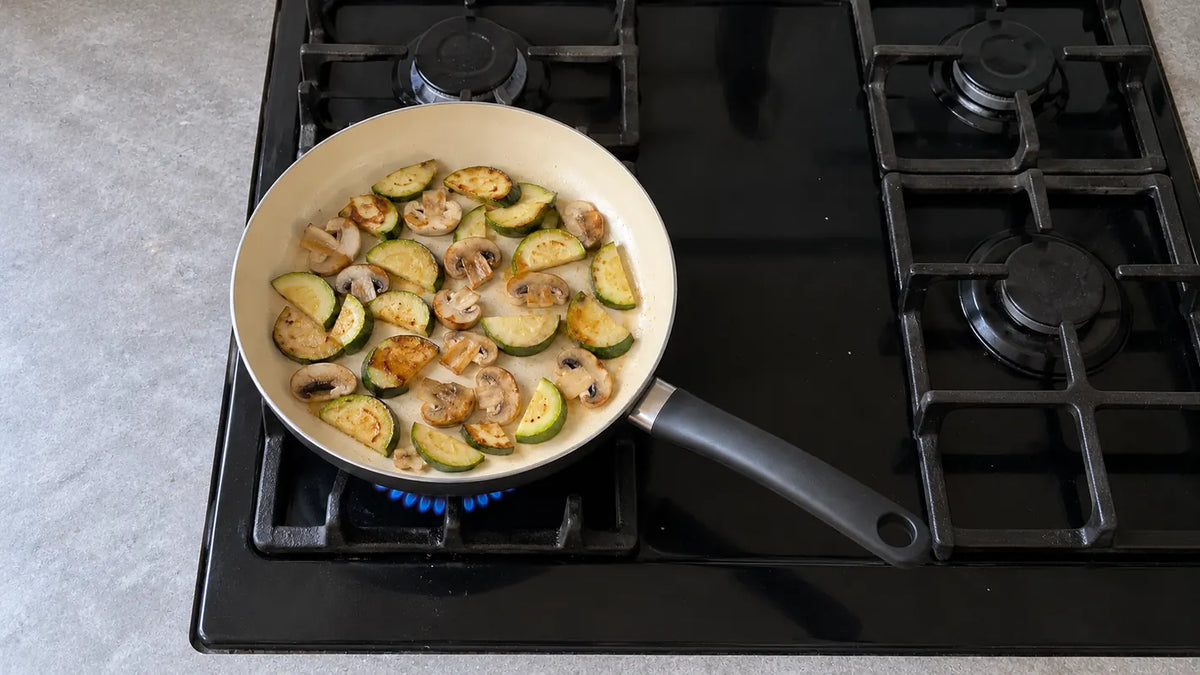 Inconvénients d'une poêle en céramique : des courgettes et des champignons qui dorent doucement sur une petite flamme