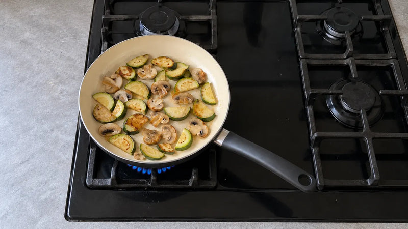 Inconvénients d'une poêle en céramique : des courgettes et des champignons qui dorent doucement sur une petite flamme