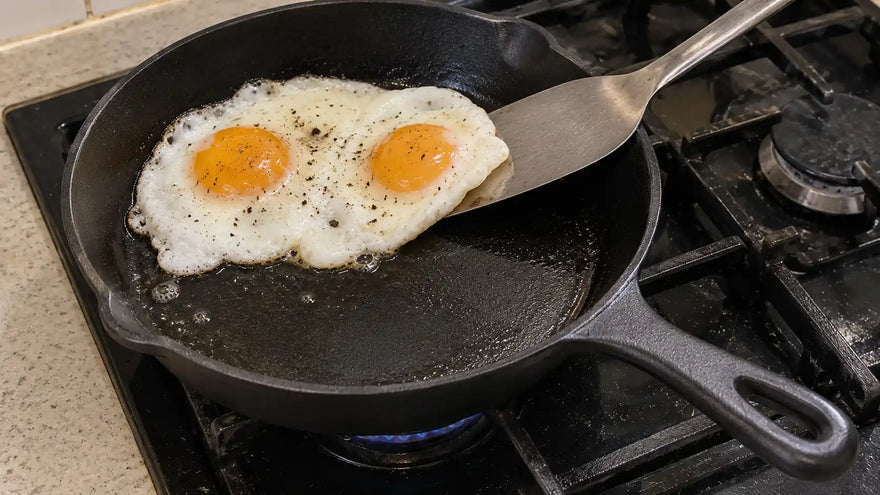 Comment faire pour que ma poêle en fonte ne colle pas : deux œufs au plat se détachent, soulevés par une spatule fine