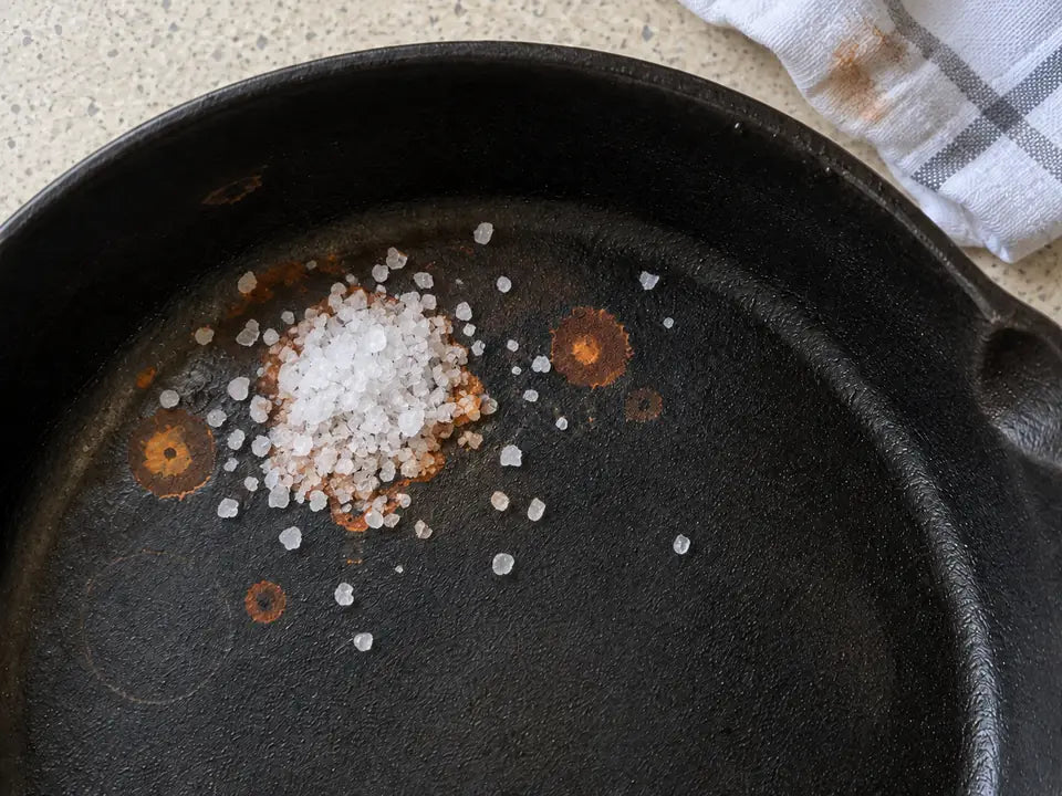 Peut-on cuisiner dans une poêle en fonte rouillée : du gros sel versé sur la tache de rouille, un torchon humide posé à côté