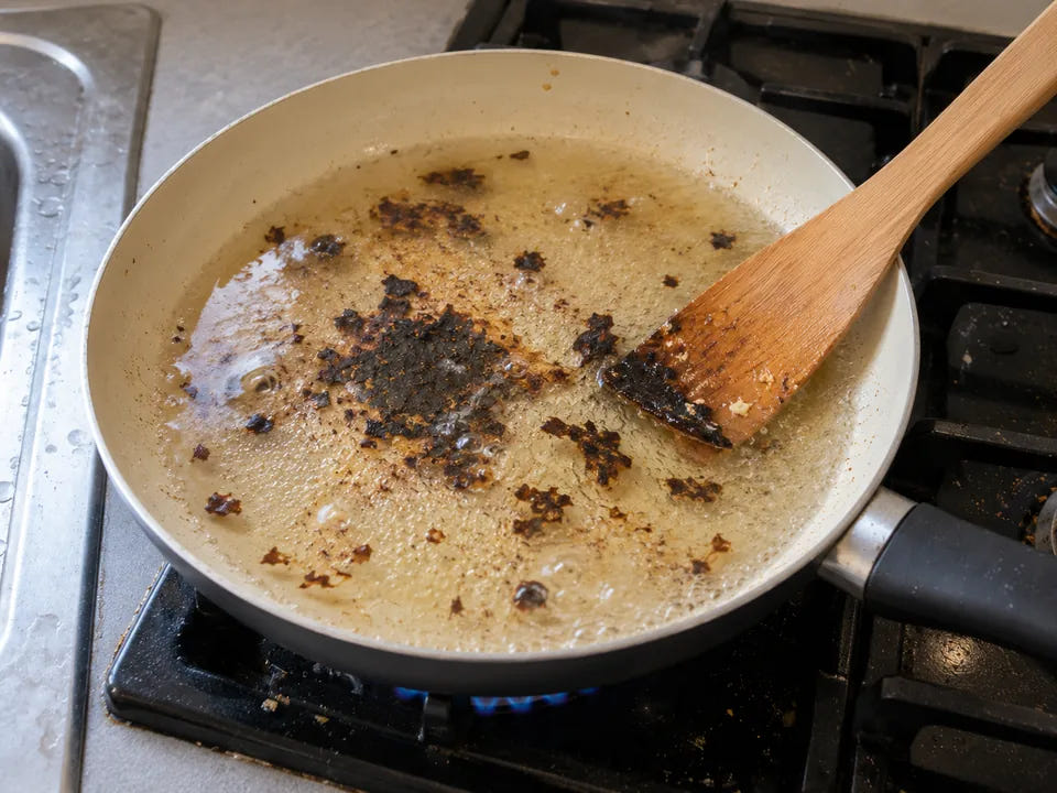 Nettoyer une poêle en céramique brûlée : l'eau frémit à petites bulles pendant que la spatule en bois soulève le brûlé