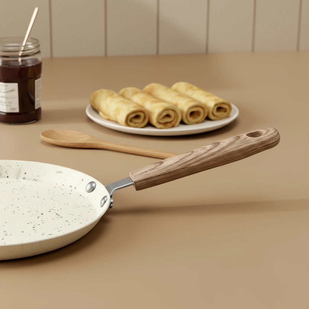 Gros plan sur le manche effet bois de la poêle à crêpe 18 cm, crêpes roulées servies en arrière-plan.