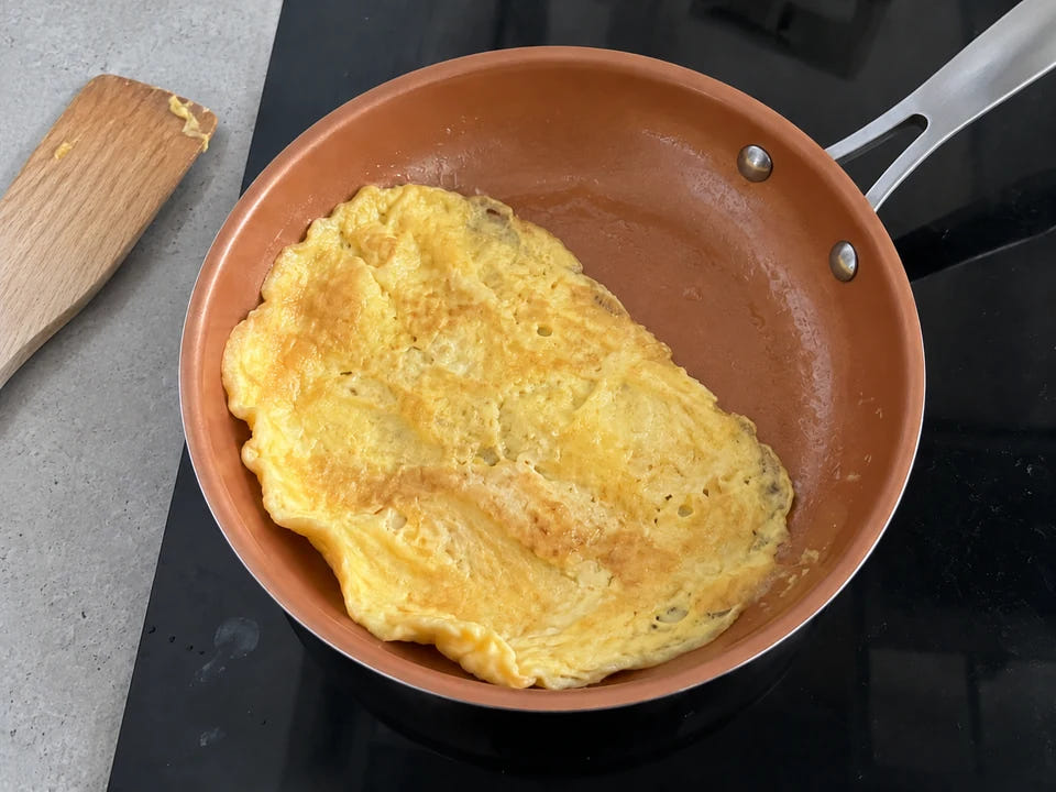 Poêle anti-adhérente en céramique sur une plaque à induction : l'omelette dorée se détache et glisse sans accrocher