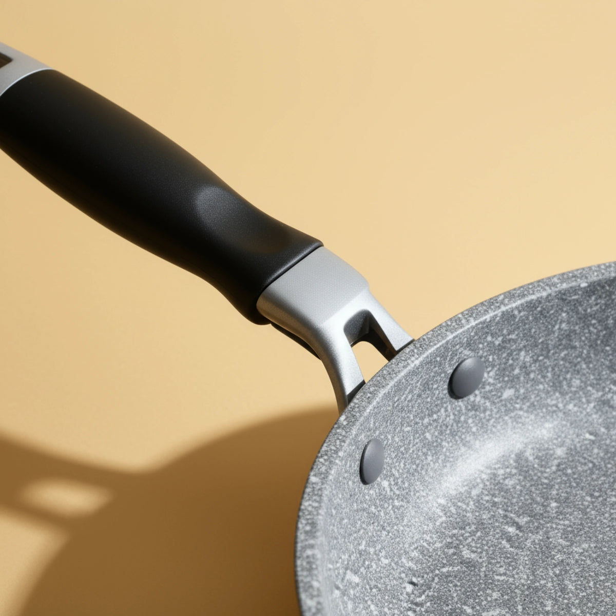 Détail de la fixation rivetée de la poignée sur la poêle en aluminium 20 cm. Solidité et durabilité pour une utilisation intensive.