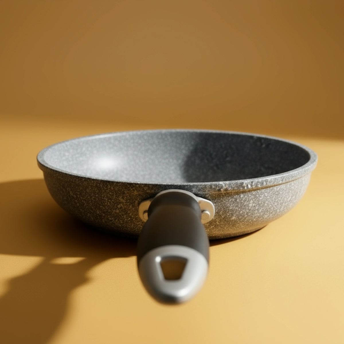 Vue de face de la poignée de la poêle en aluminium 26 cm effet pierre. Poignée conçue pour rester froide et offrir une prise en main sécurisée.