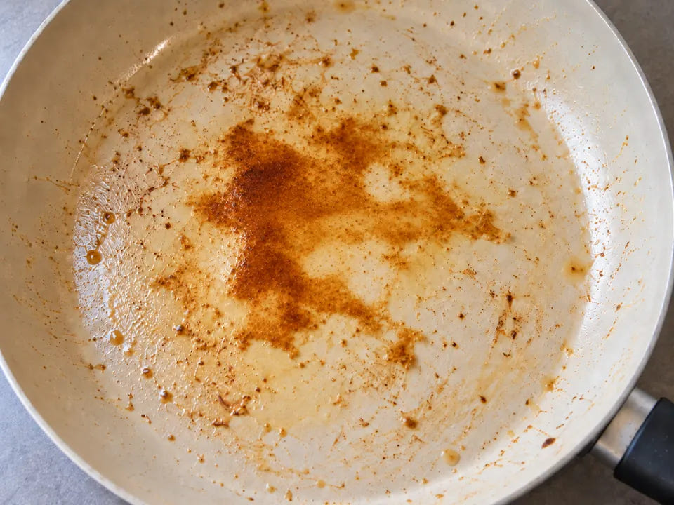 Poêle en céramique brûlée : une pellicule brune et luisante d'huile cuite qui s'étale sur la surface de cuisson