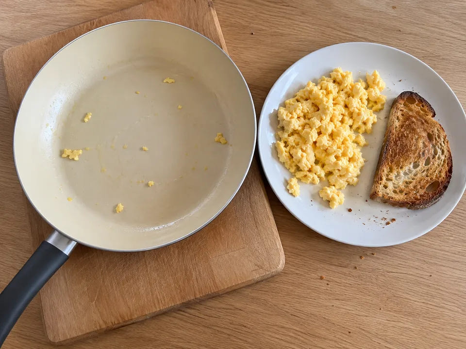 Une poêle en céramique vaut-elle le coup : des œufs brouillés servis avec une tartine grillée, la poêle presque propre à côté