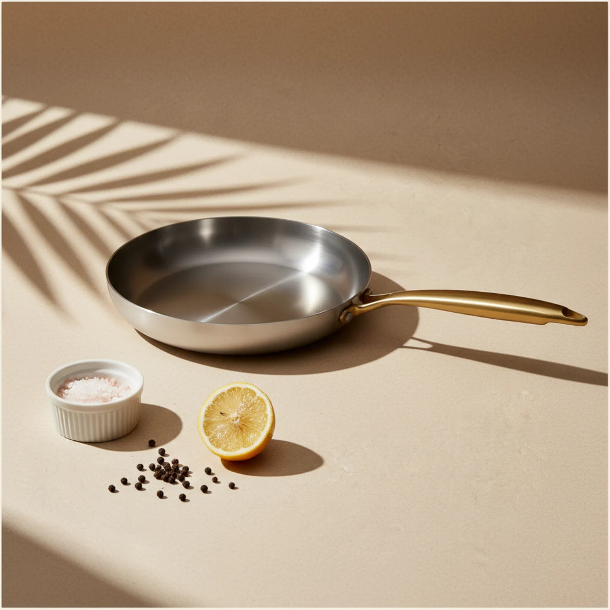 Poêle induction 26 cm vue de dessus, un demi-citron, du sel et du poivre posés à côté