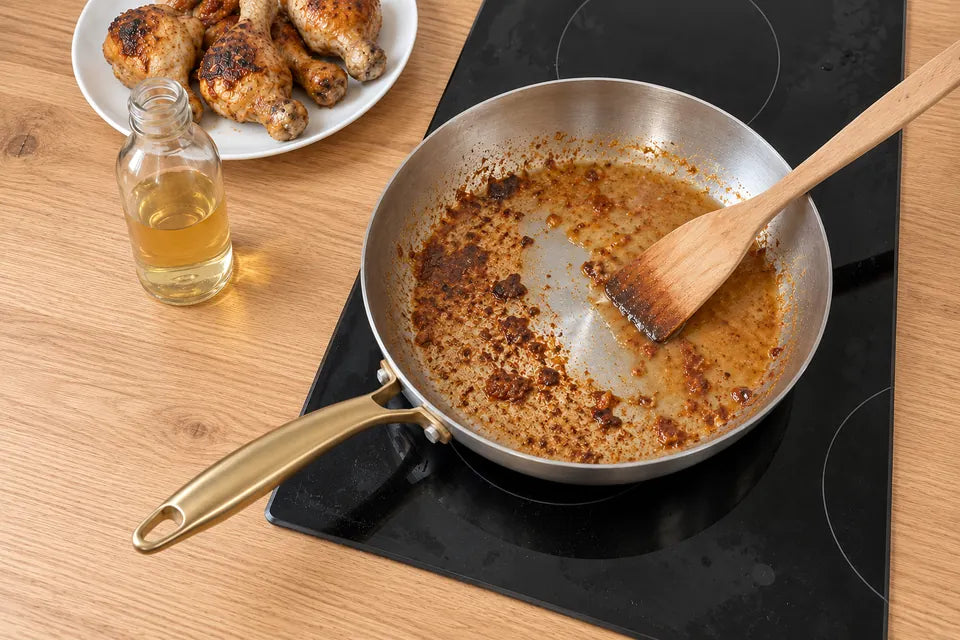 Poêle en inox 18/10 sur une plaque à induction : du vinaigre versé dans la poêle chaude décolle les sucs du poulet