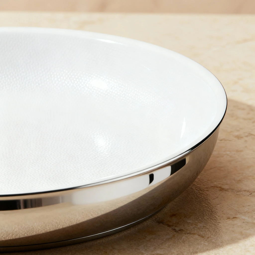 Poêle inox céramique : détail de l’intérieur blanc et de la paroi extérieure brillante.