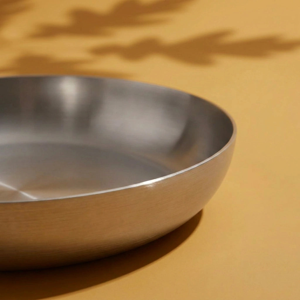 Surface de cuisson brossée et bord arrondi de la poêle tous feux 24 cm, vus en gros plan