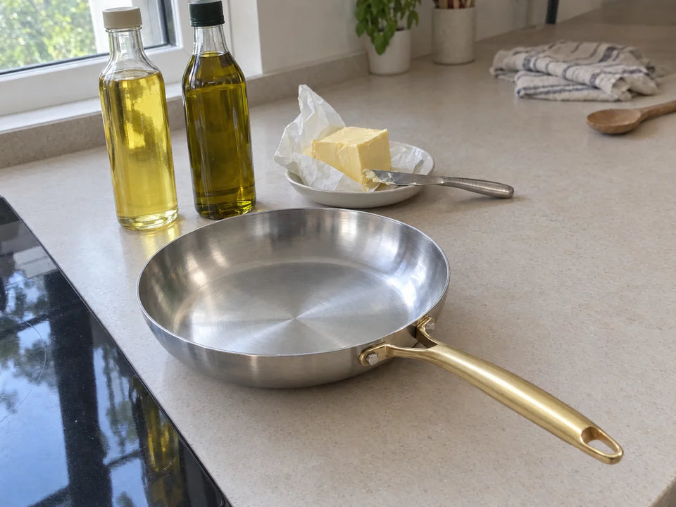 Quelle huile pour une poêle en inox : huile de tournesol, huile d'olive et beurre posés à côté de la poêle