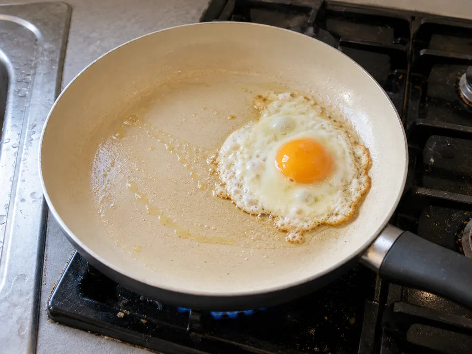 Récupérer une poêle en céramique : un œuf au plat cuit au beurre qui se détache de la poêle nettoyée, sur un feu doux