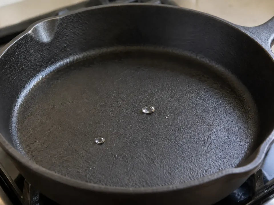 Test de la goutte d'eau : une bille d'eau qui roule sur la surface de cuisson d'une poêle en fonte bien préchauffée