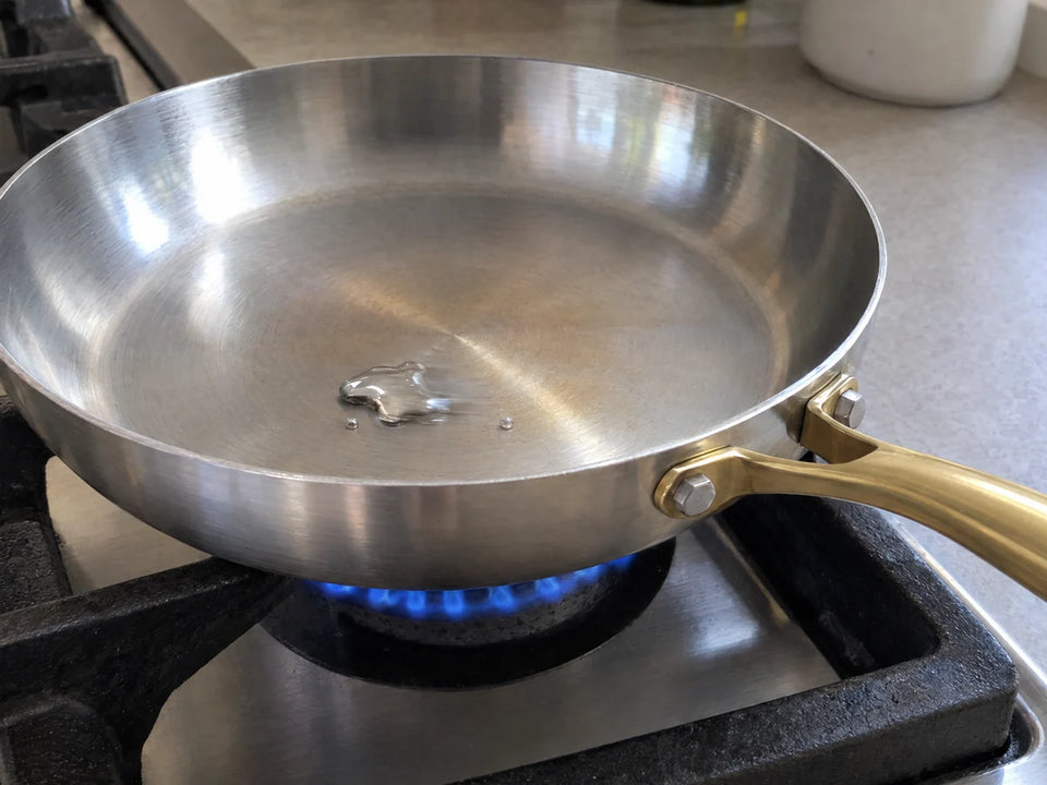 Préchauffer une poêle en inox au gaz : une goutte d'eau y roule en bille, signe que la bonne température est atteinte