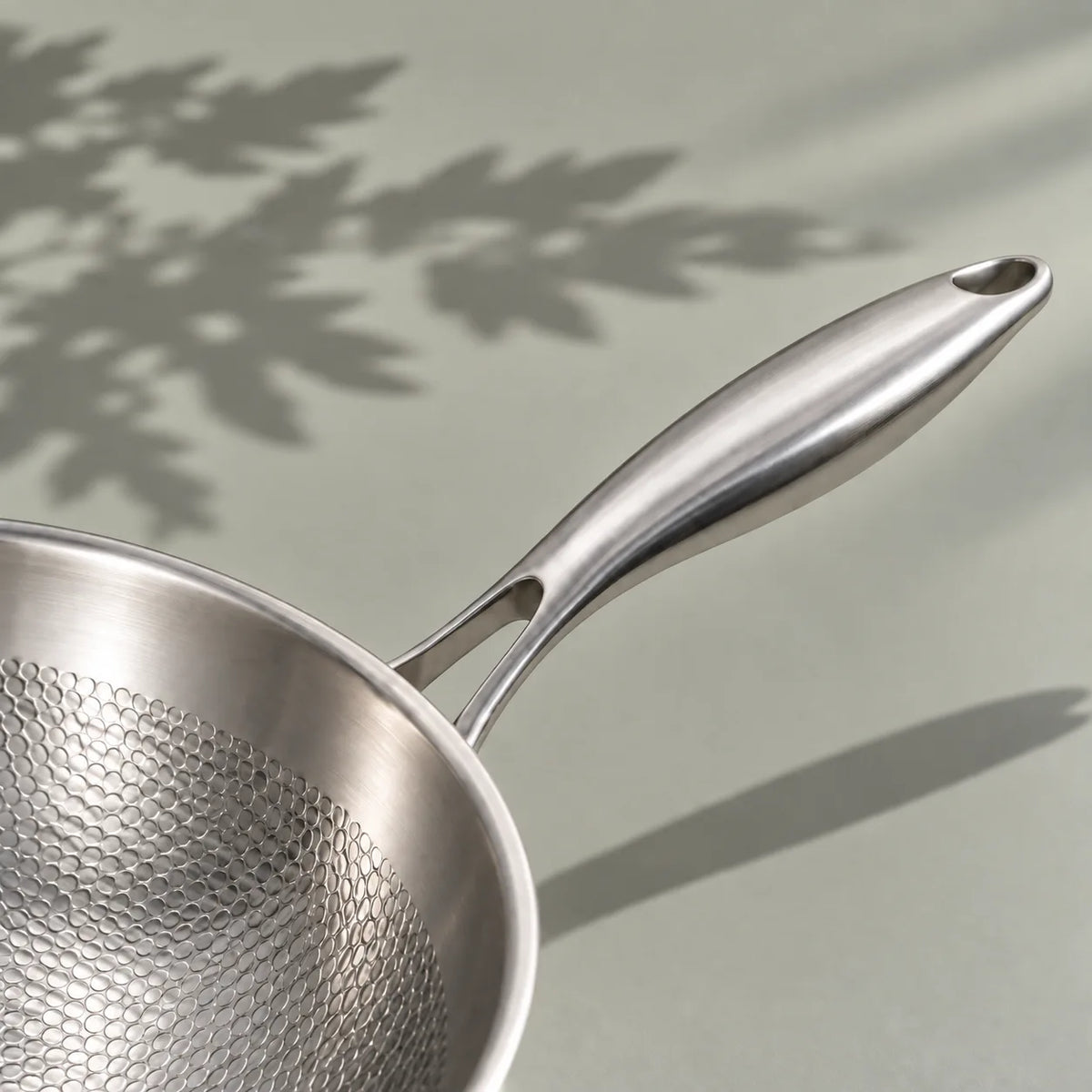 Manche long et galbé du wok en titane martelé 32 cm, avec son attache en fourche et son trou de suspension